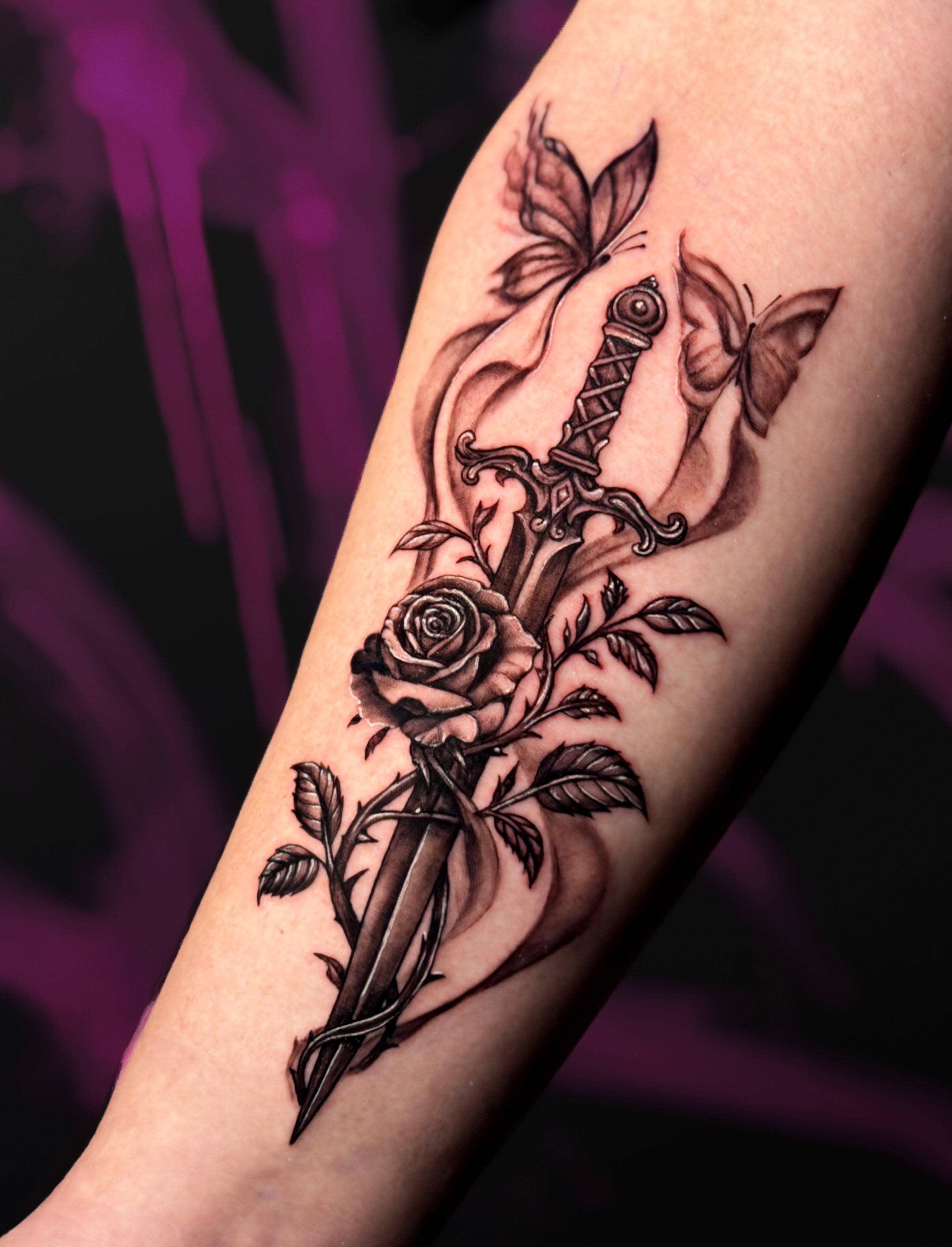 Fine-line dagger and rose tattoo